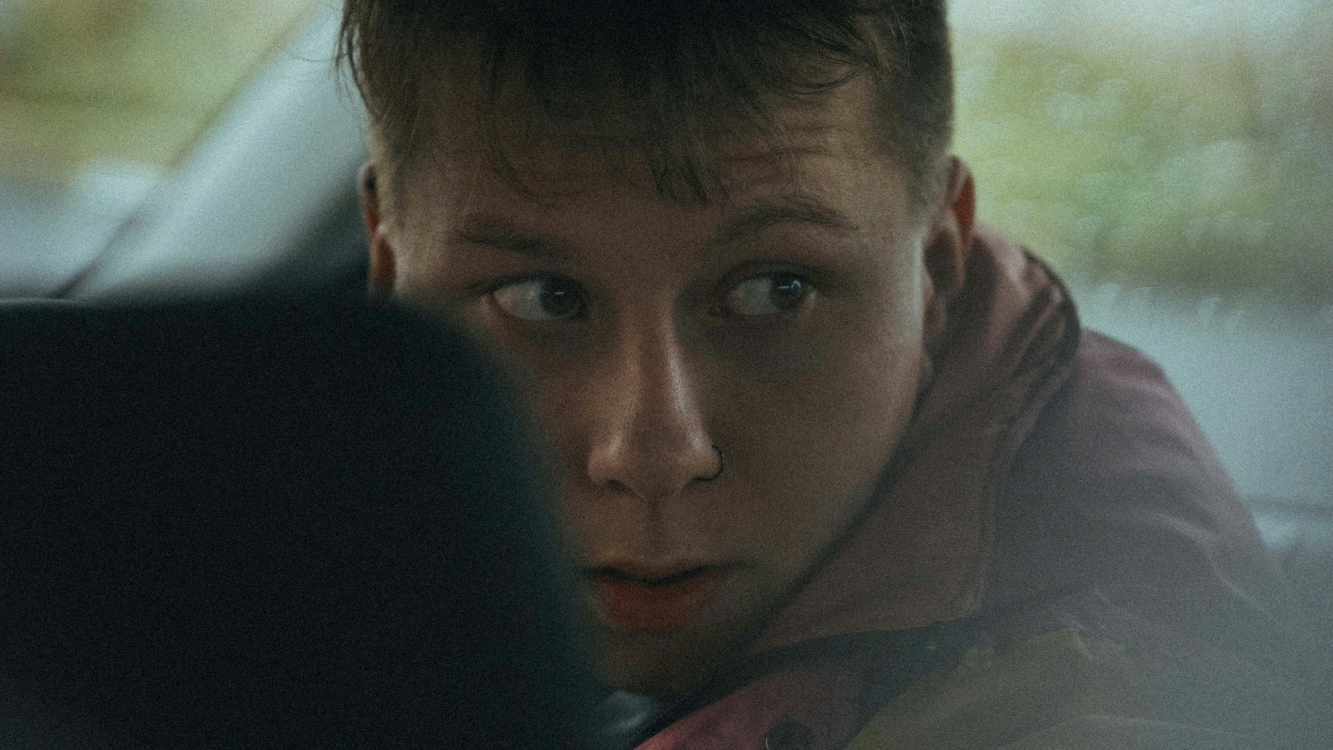 man in brown jacket sitting on car seat