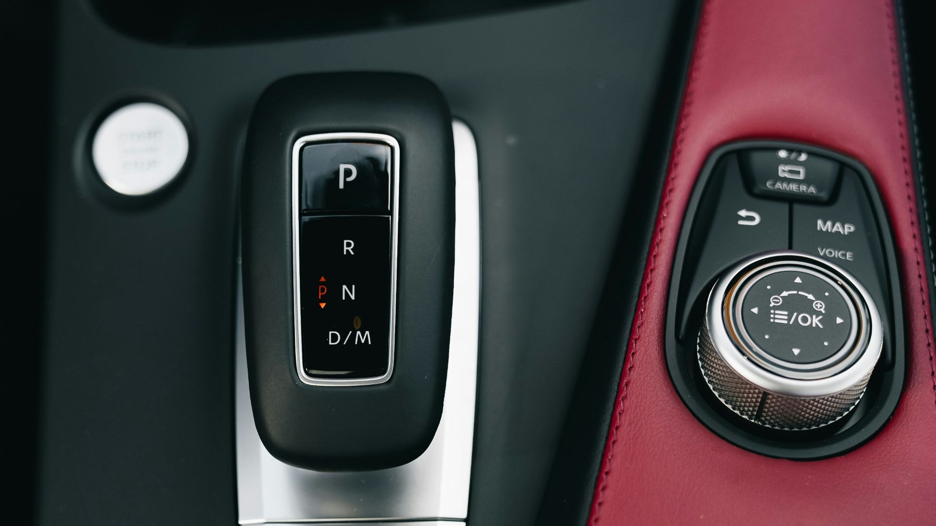 Close-up of a car's automatic gear shifter and control dial.