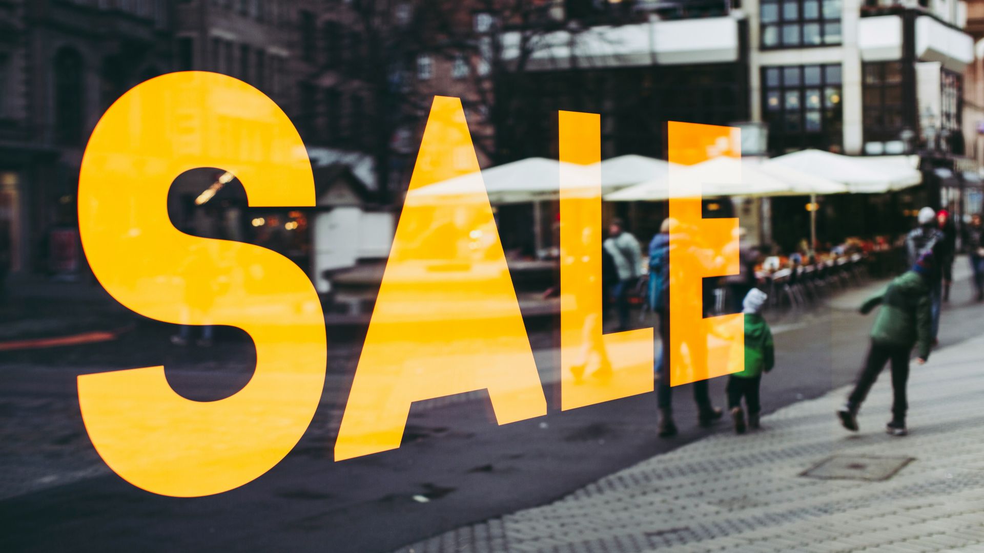 man in green jacket walking on sidewalk during daytime