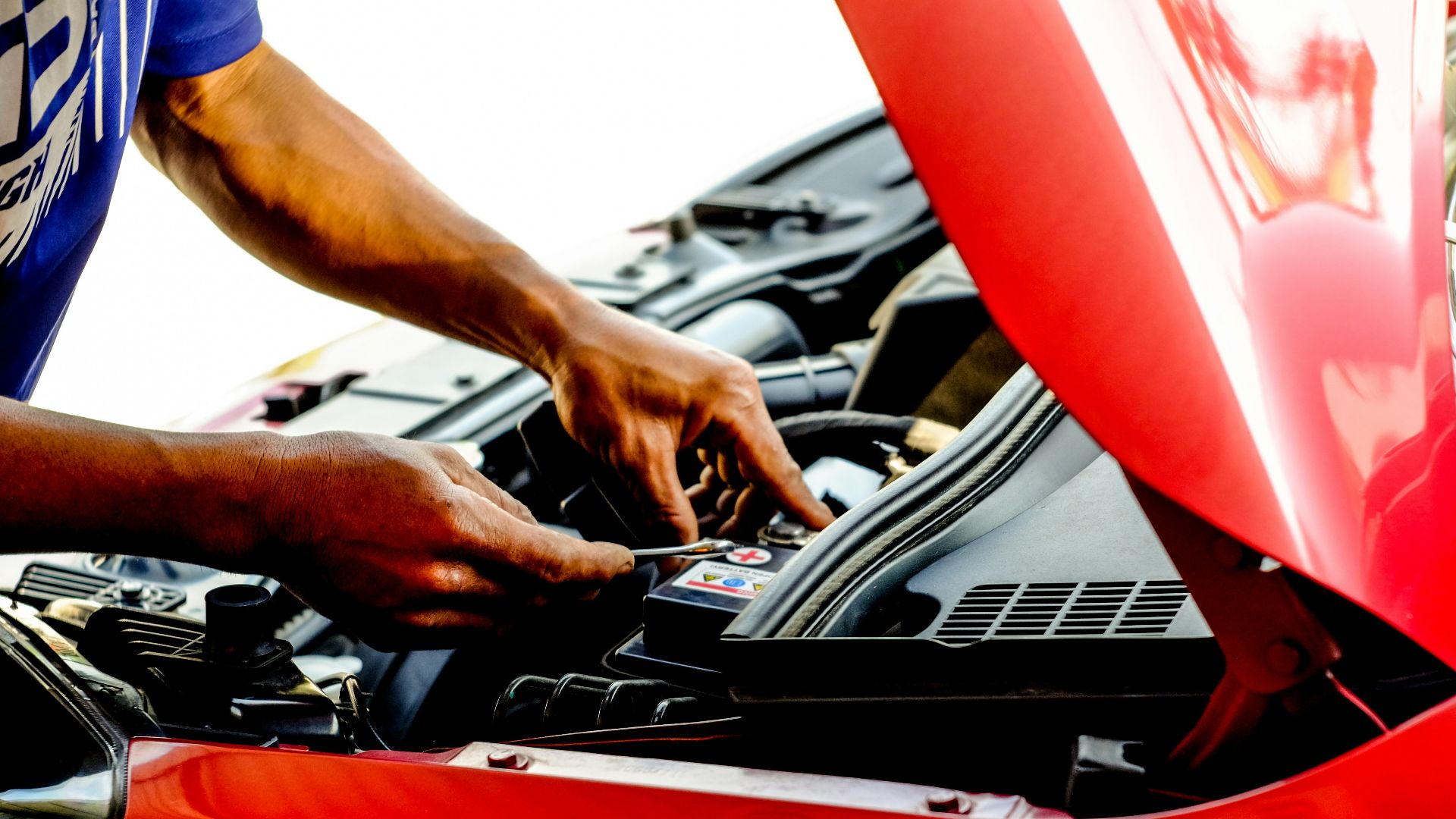 person fixing car during daytime