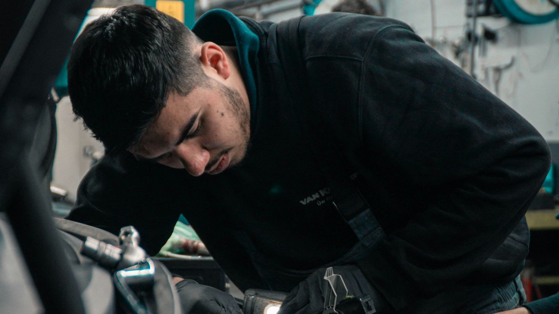 man in black jacket and blue denim jeans riding motorcycle