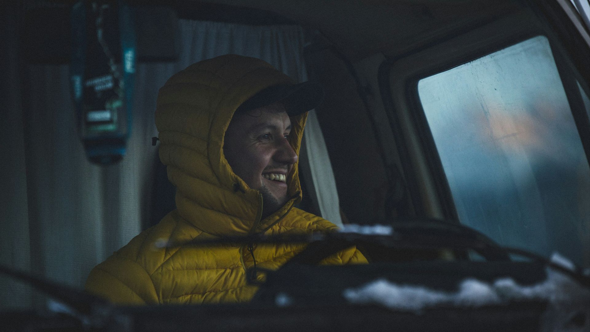 a man in a yellow jacket sitting in a car