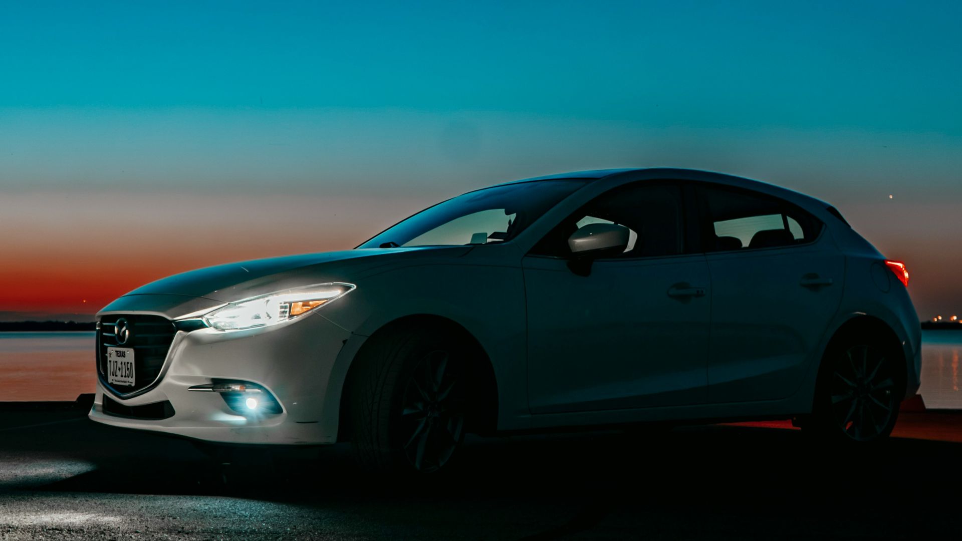 A car parked on the side of the road at night