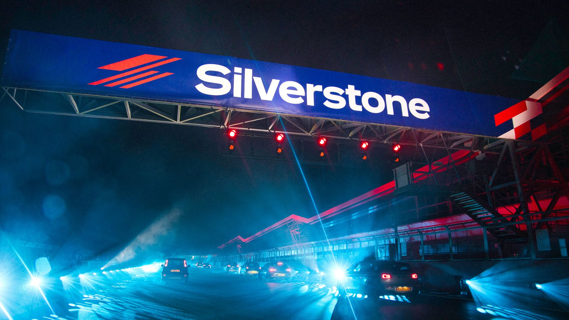 a silver stone sign above a highway at night