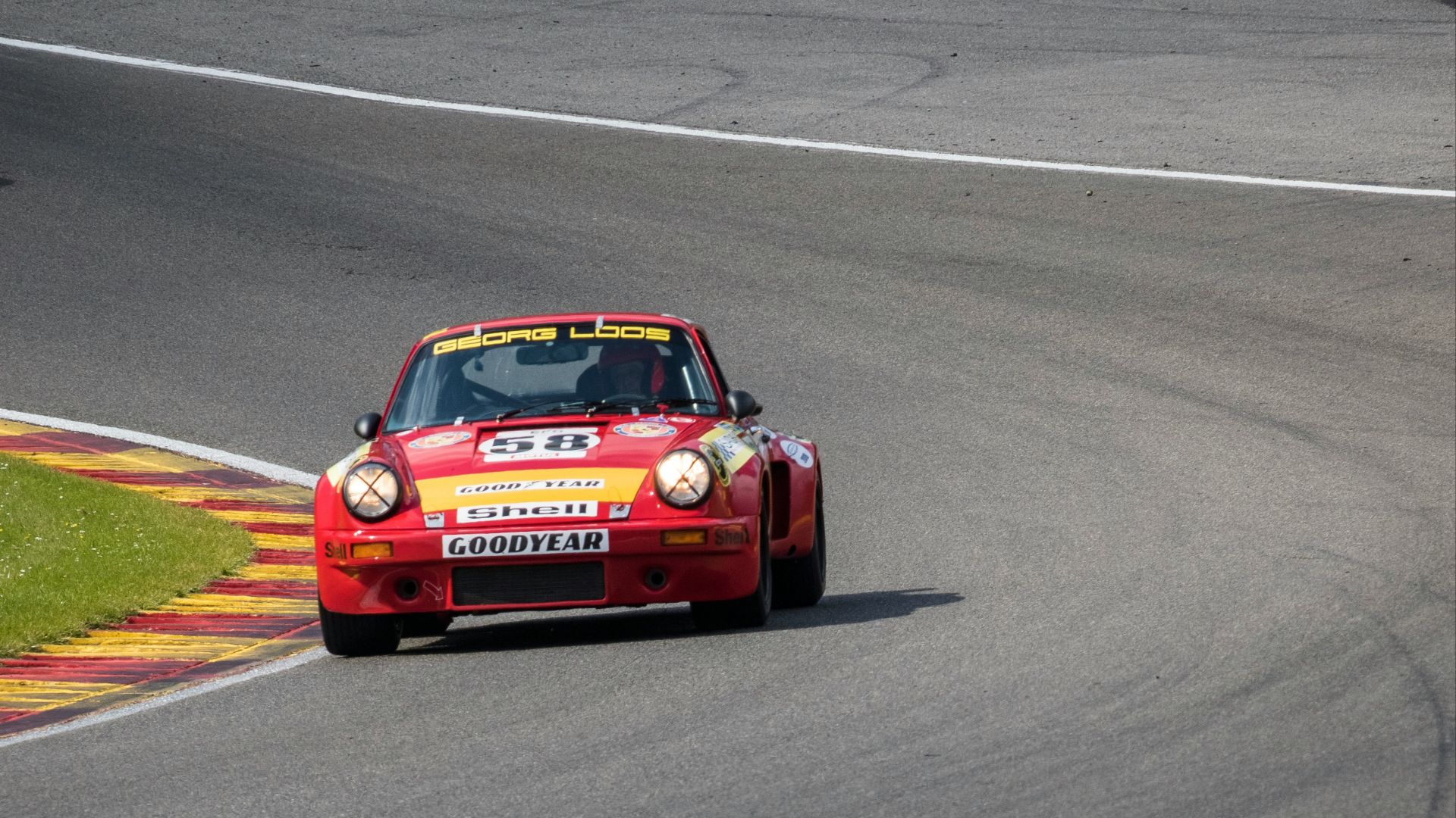 a red car driving down a race track