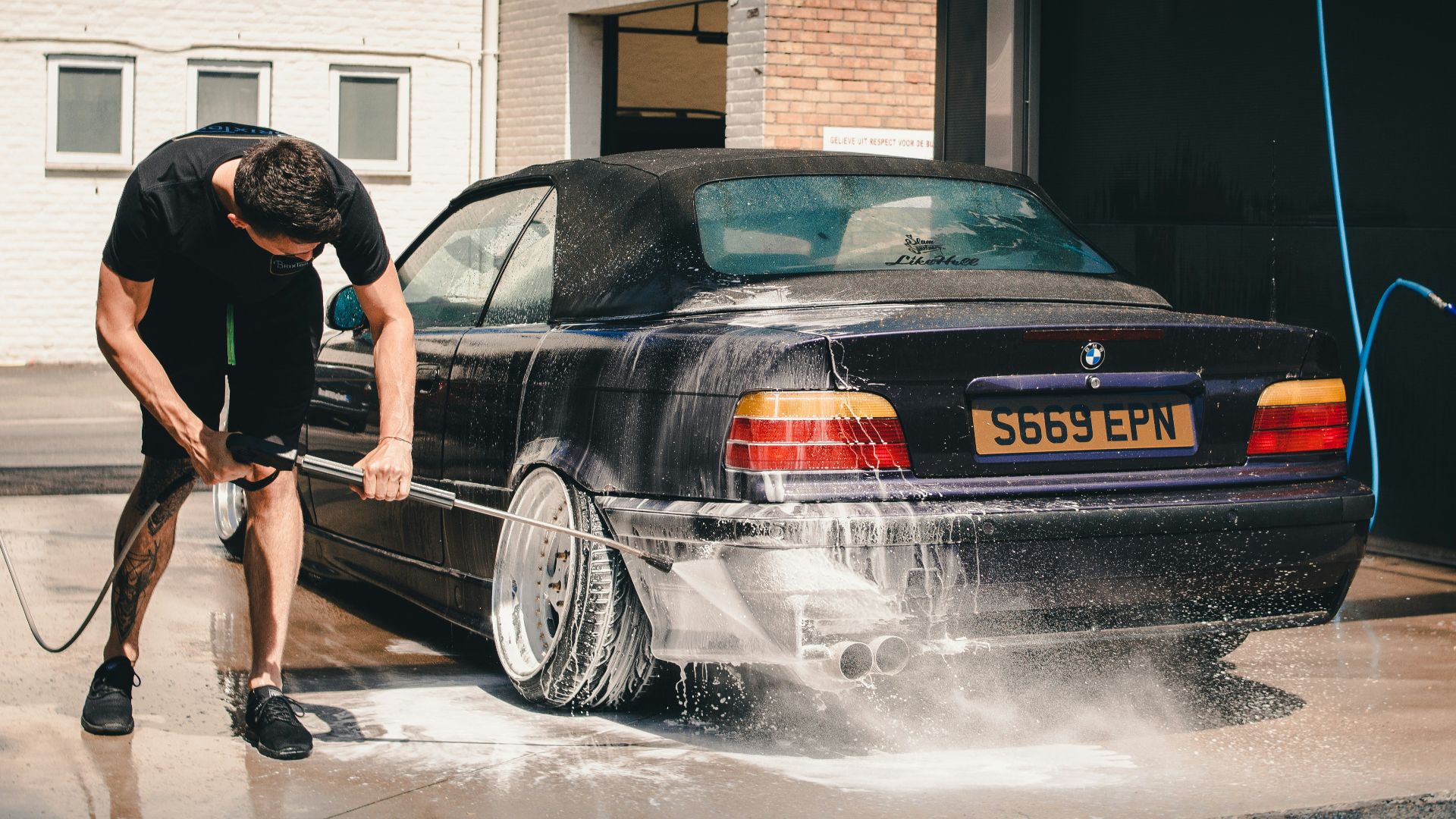 man washing BMW coupe