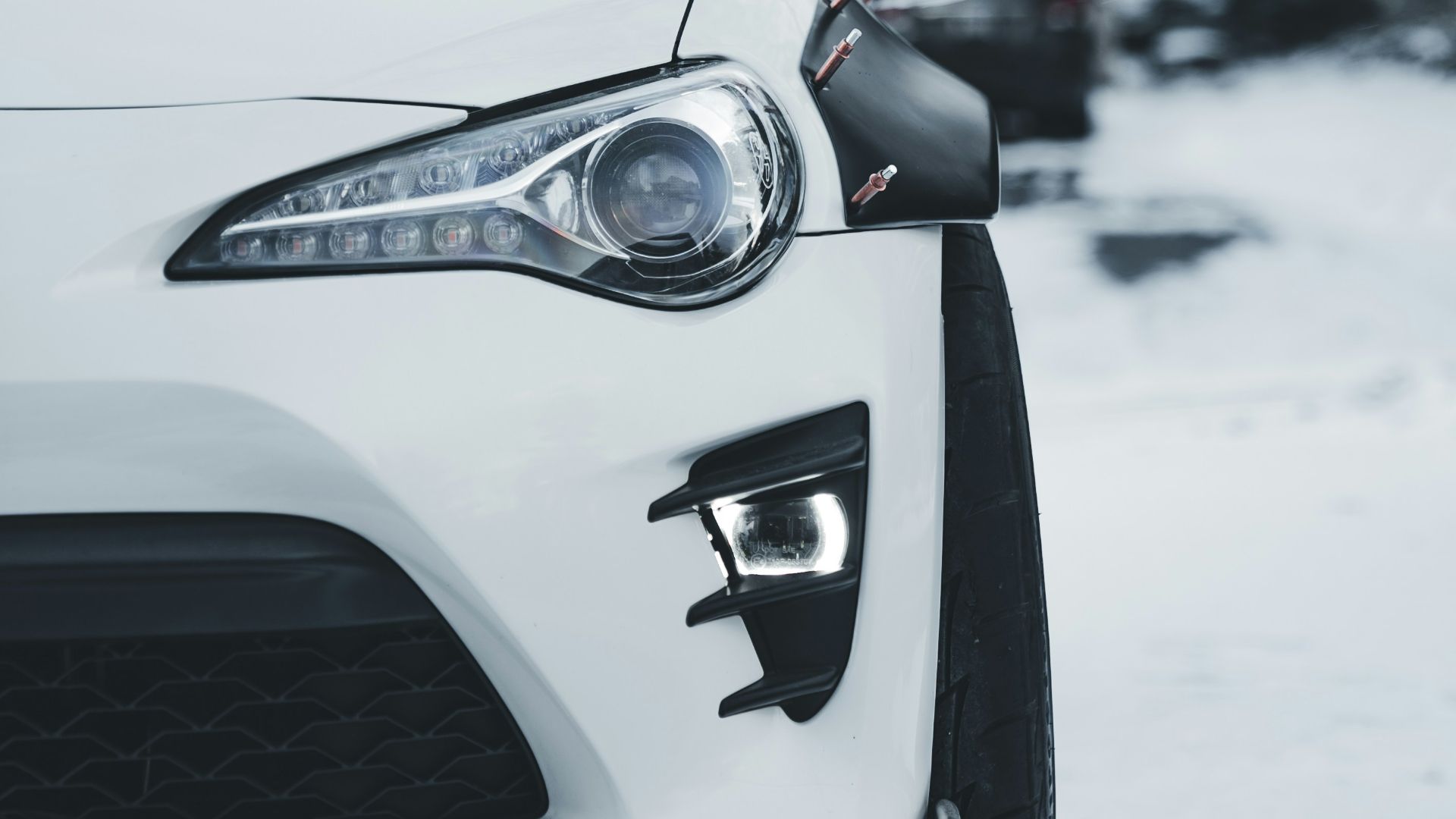 White sports car parked on a snowy road