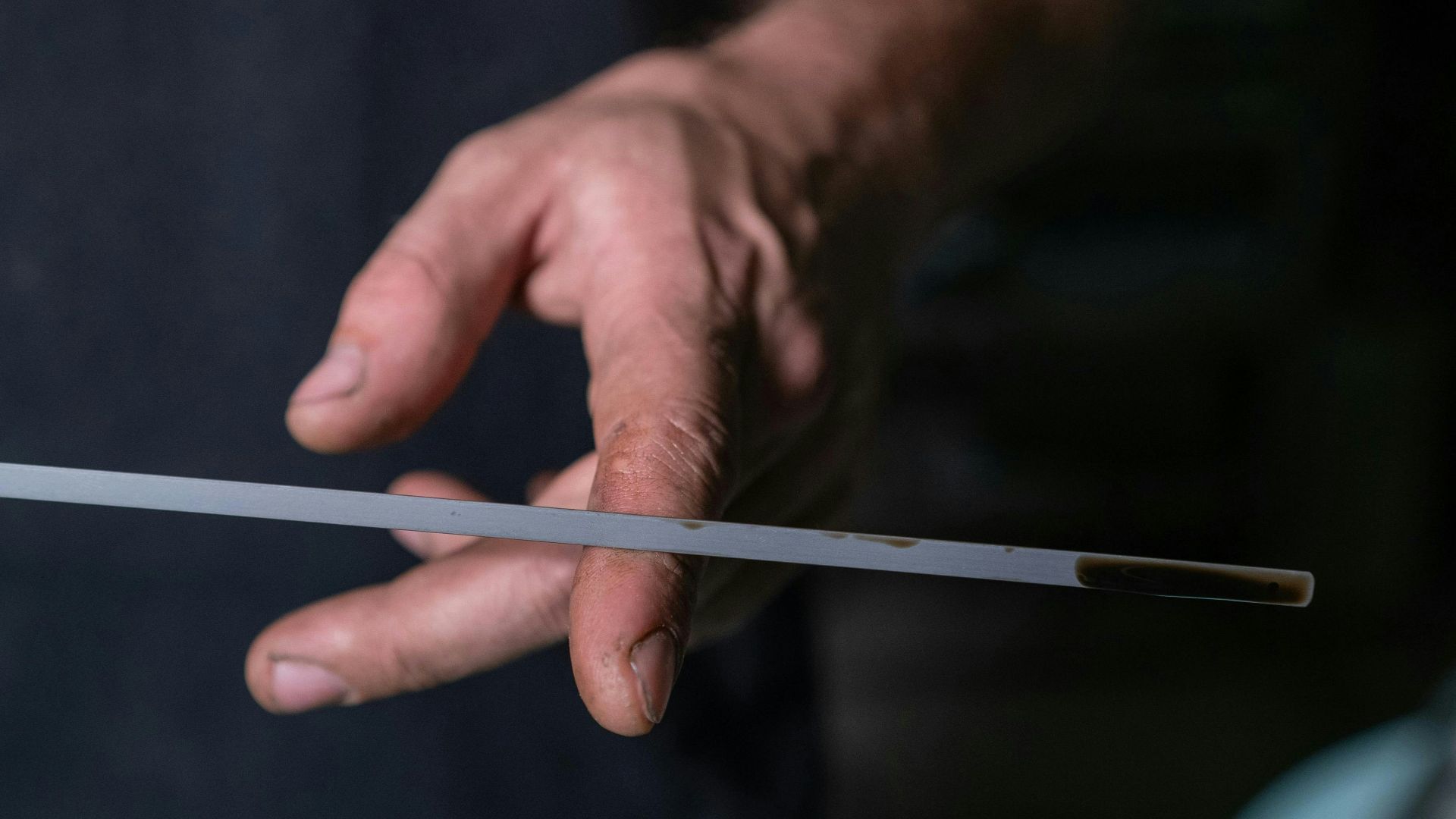 Man checking car oil with dipstick