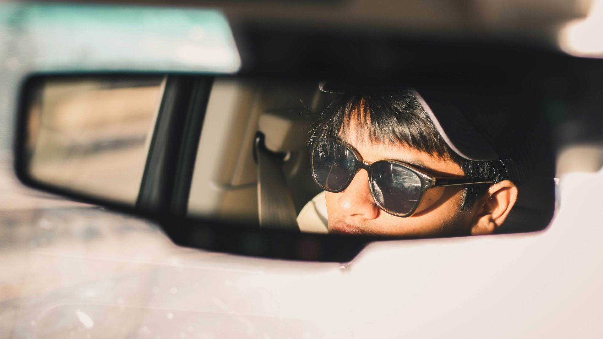 person wearing black sunglasses in car