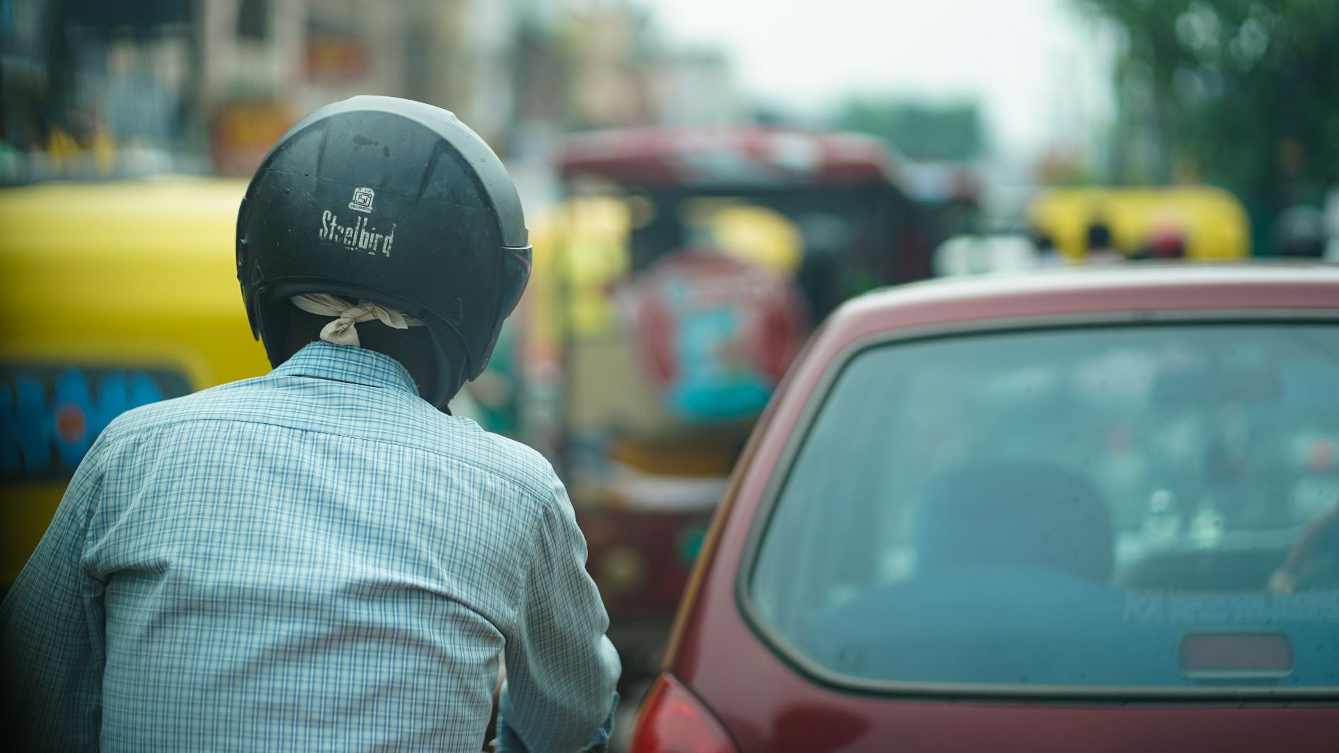 a person in a helmet looking at a car