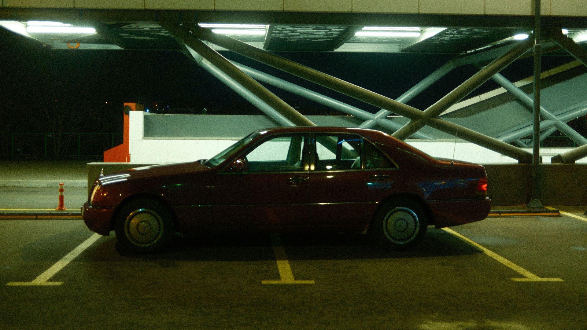 A red car is parked in a parking lot