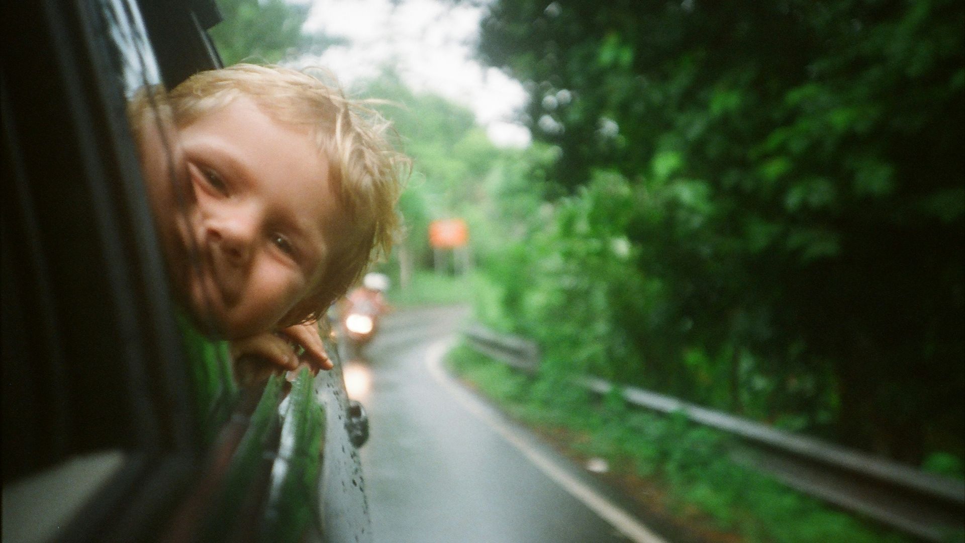 child peeking from vehicle window
