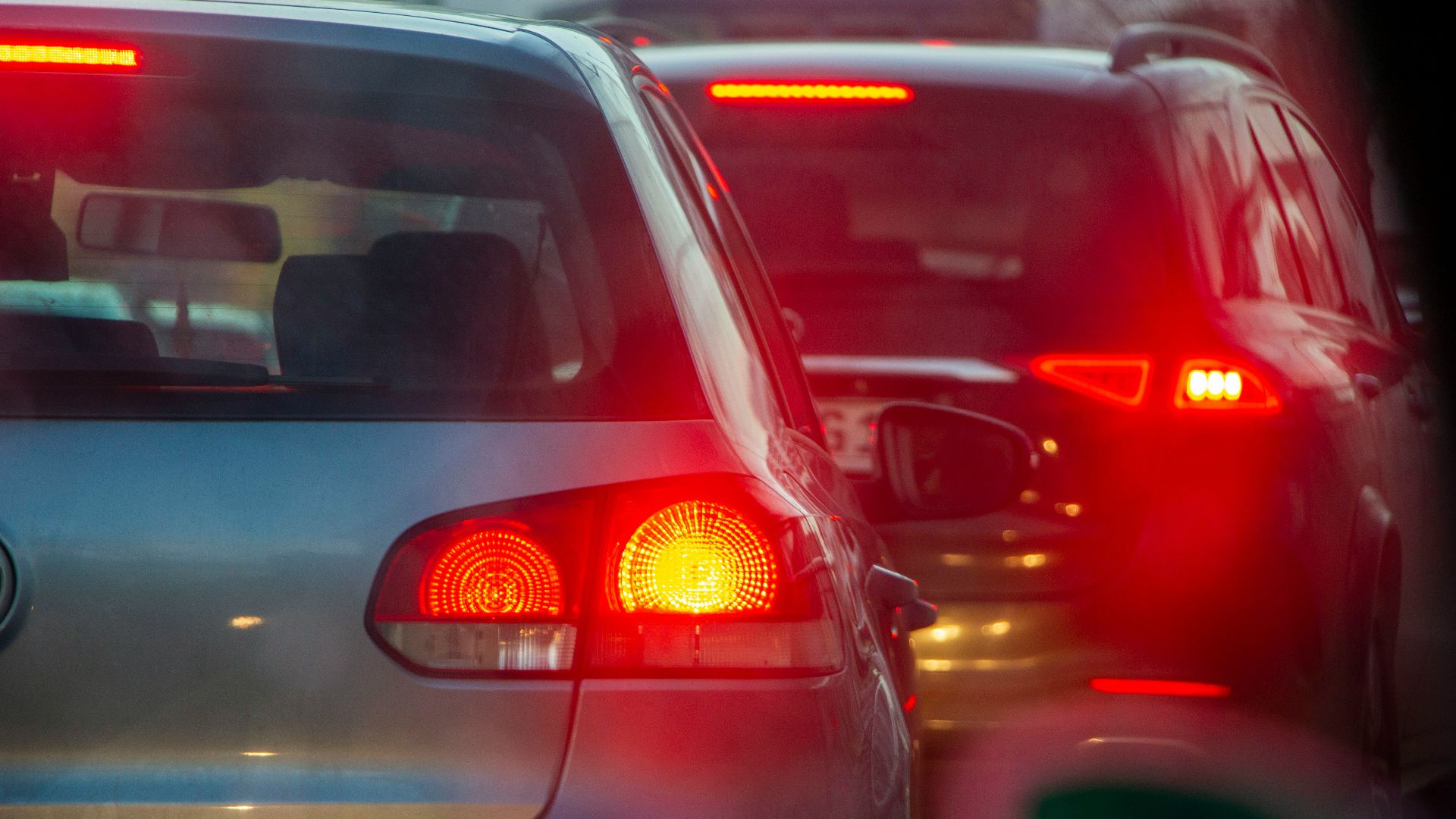 a group of cars driving down a street next to each other
