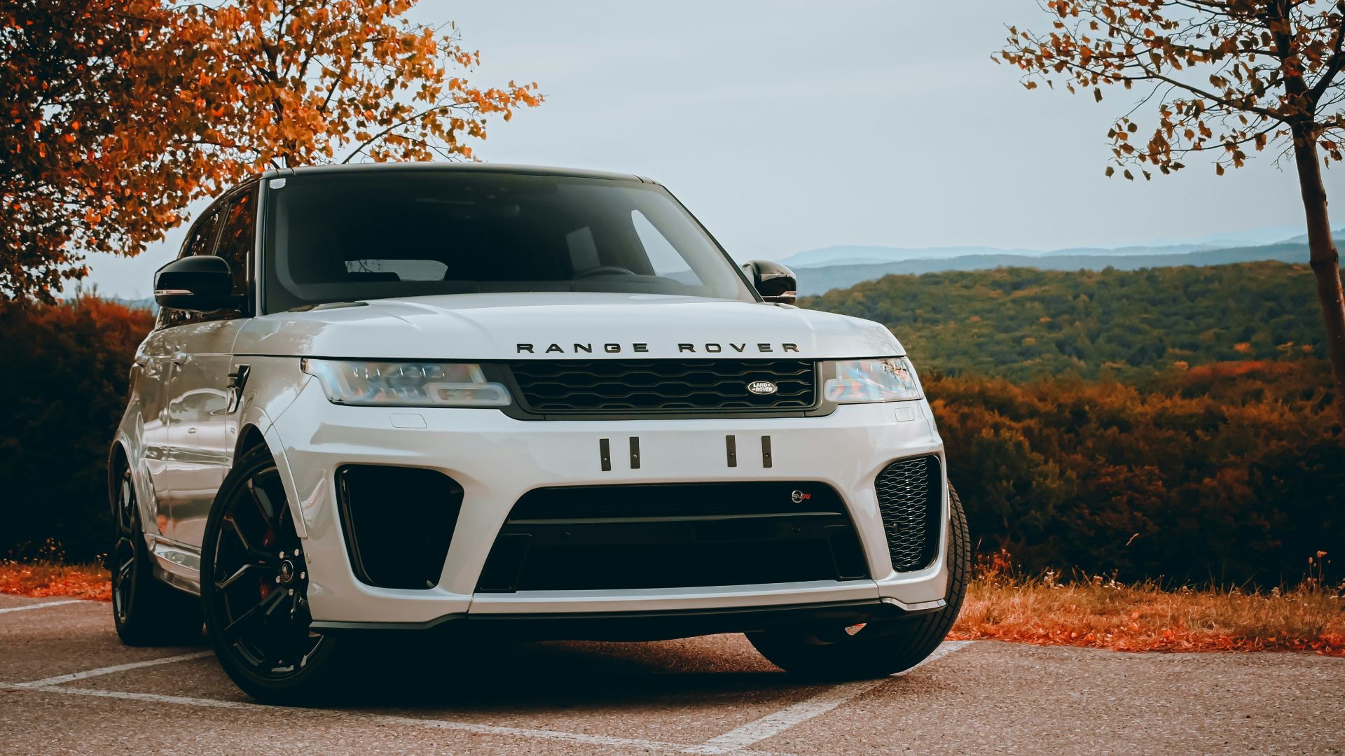 A white range rover parked in a parking lot
