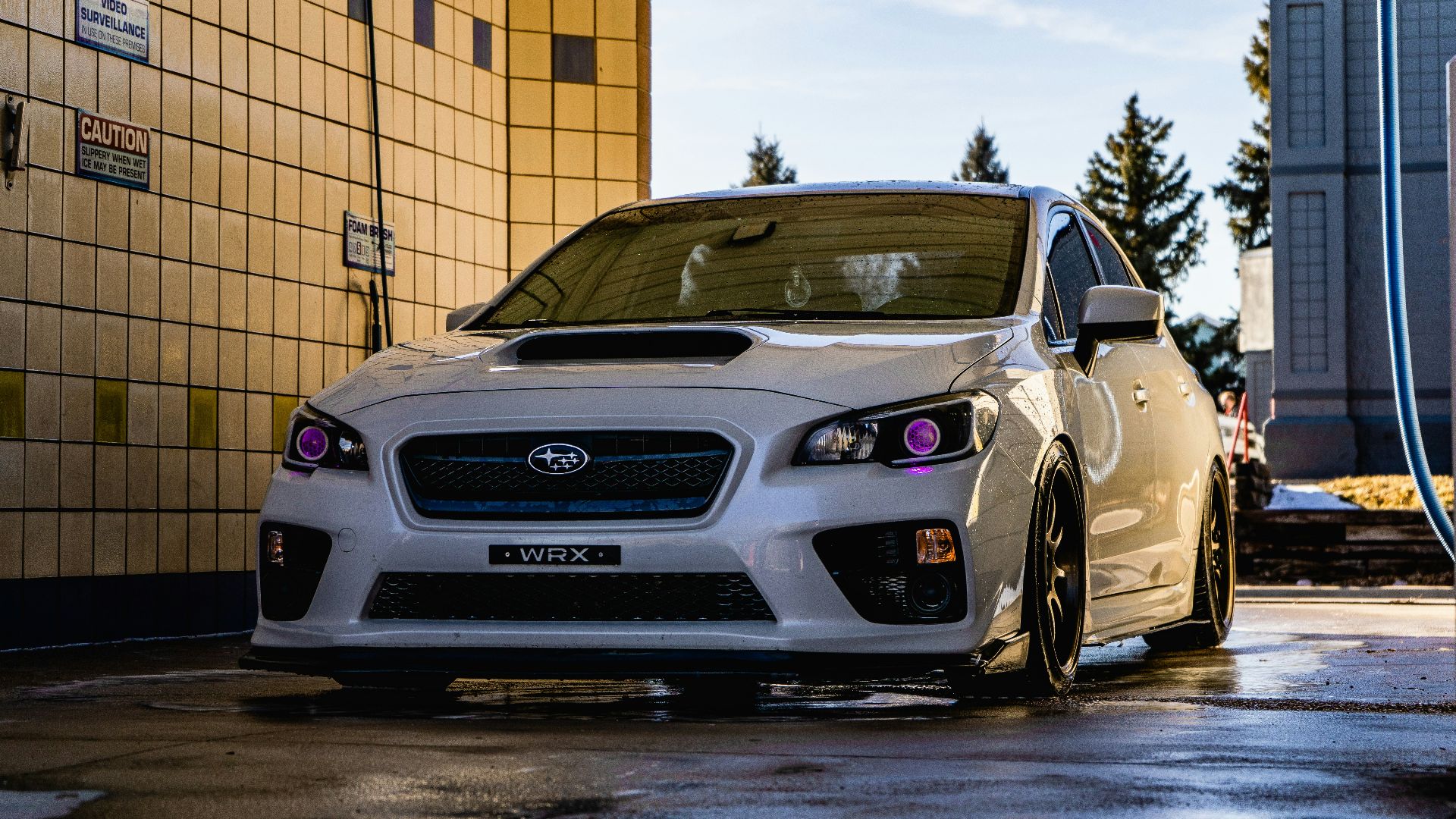 white honda car parked beside brown brick wall