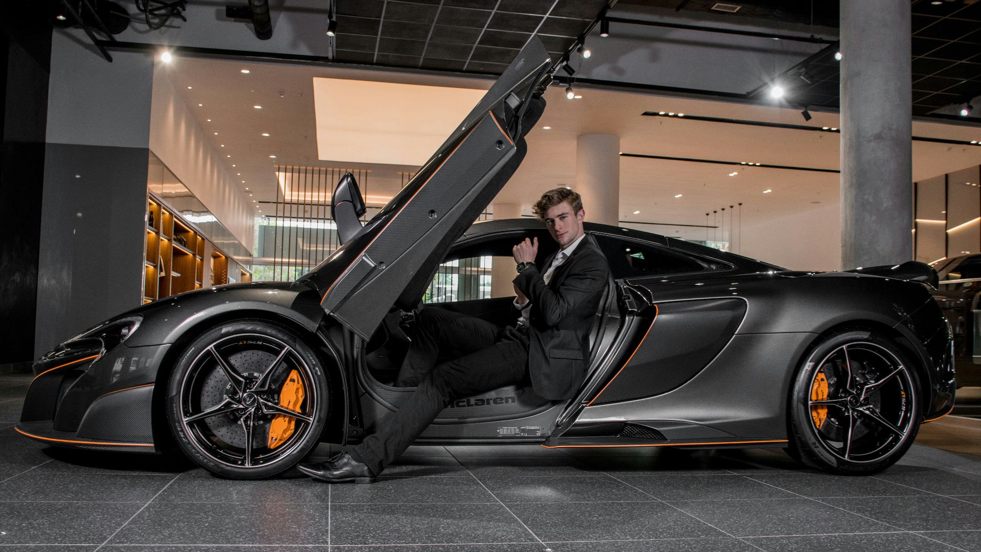 man in black jacket sitting on black car