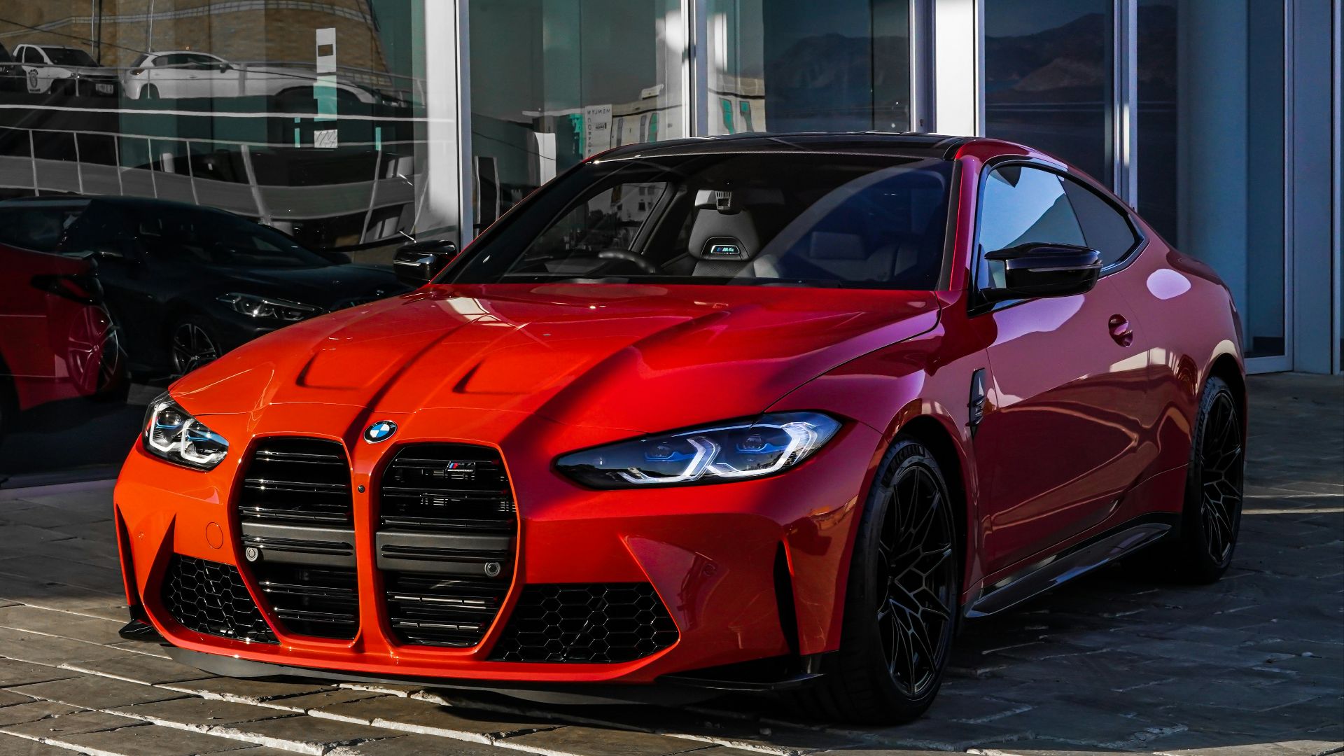 red bmw m 3 coupe parked on gray concrete pavement during daytime