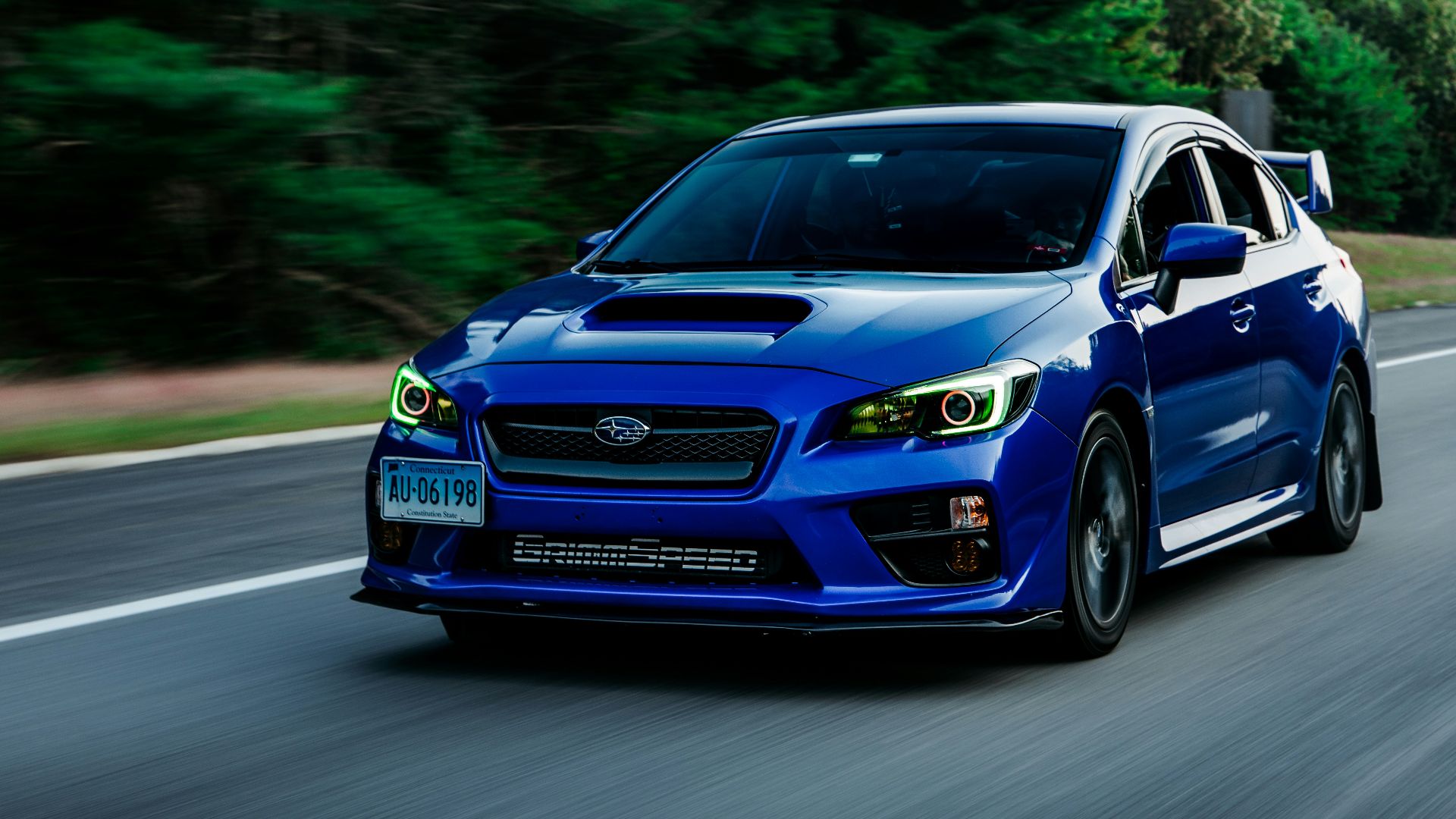 a blue subarunt is driving down the road