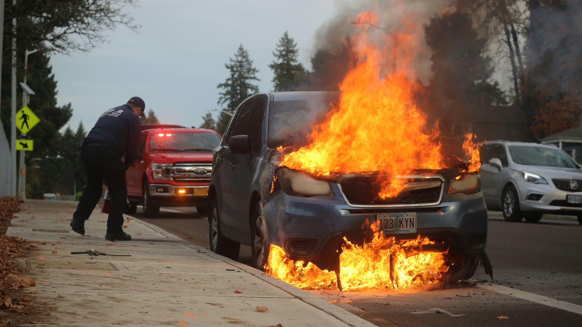 man in black jacket standing near fire