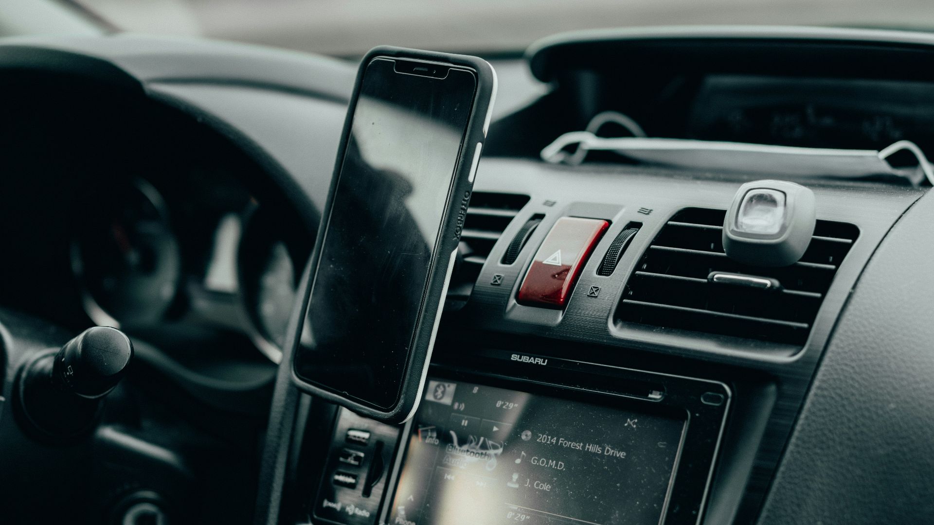 black iphone 4 on car center console