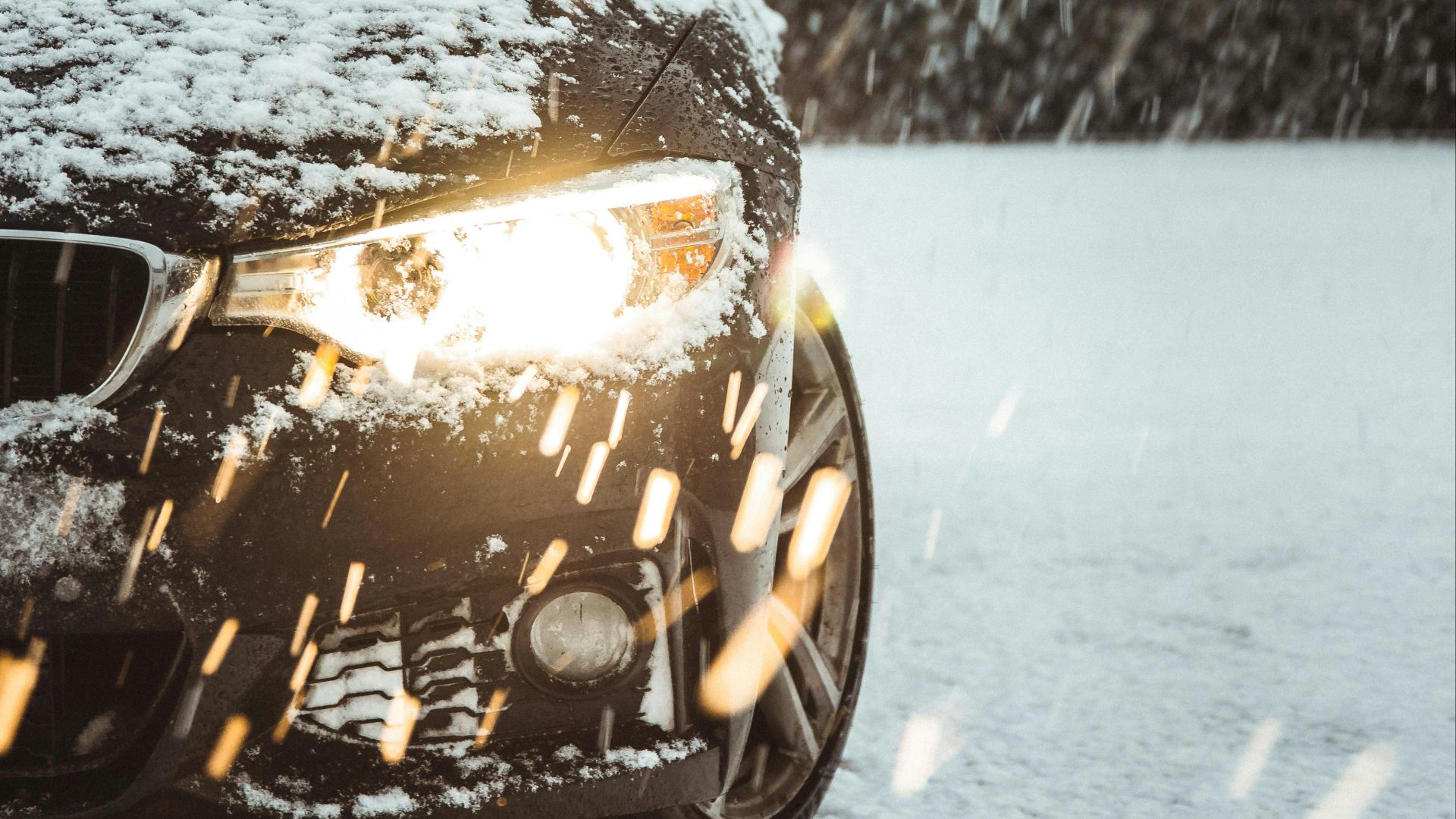 black car on snow covered road during daytime