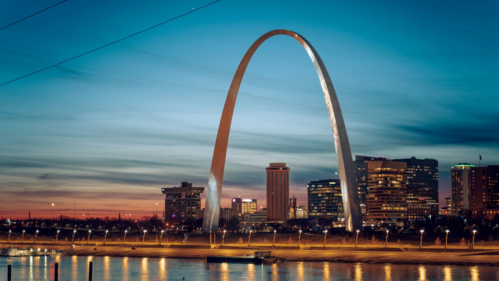 the st louis arch is lit up at night