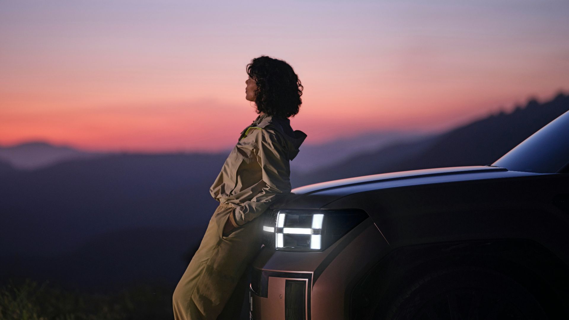 a woman sitting on the hood of a car