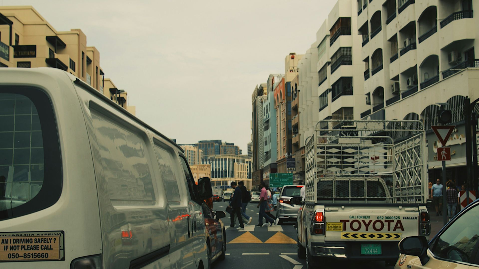 a city street filled with traffic next to tall buildings
