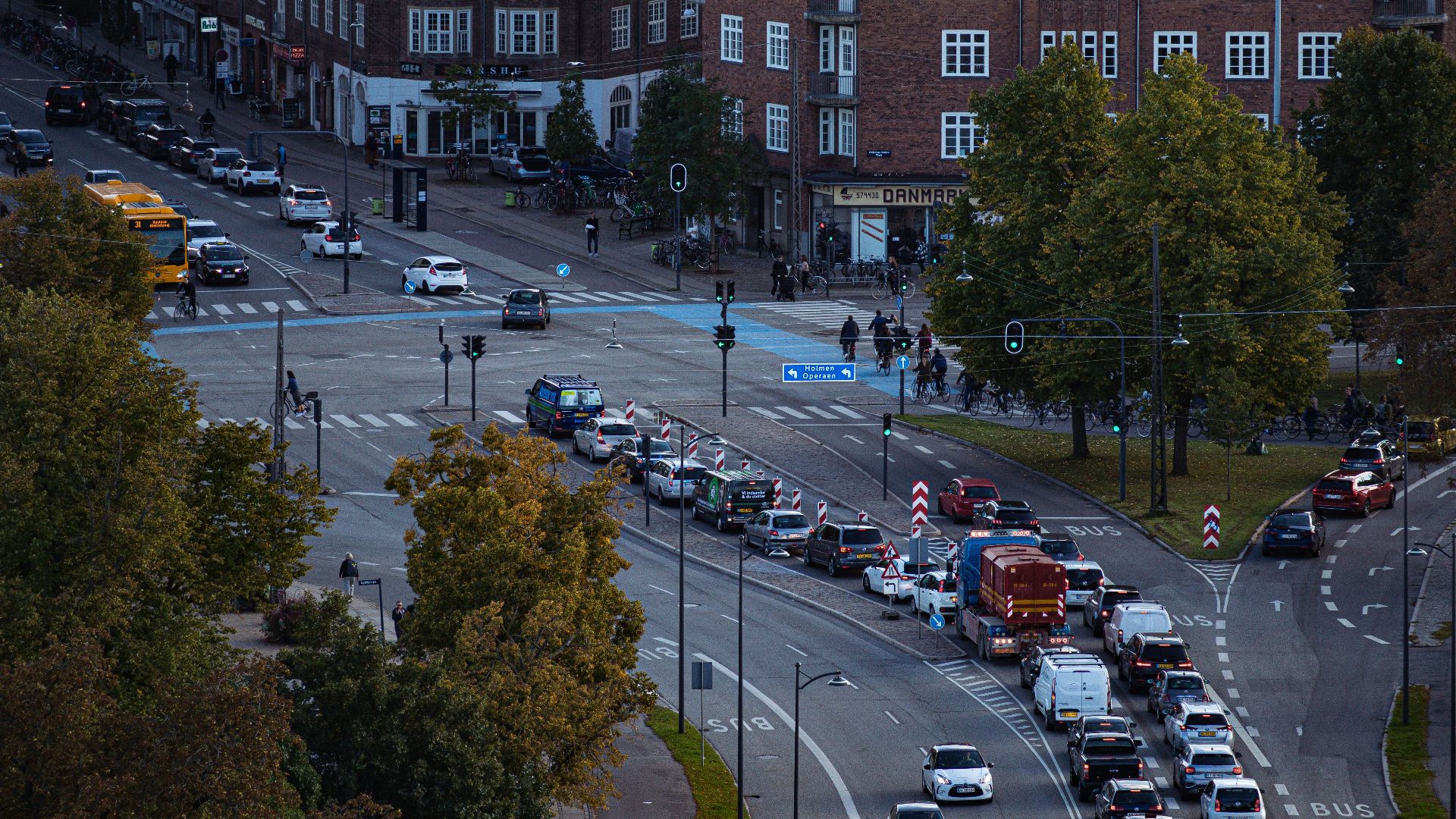 A city street filled with lots of traffic next to tall buildings