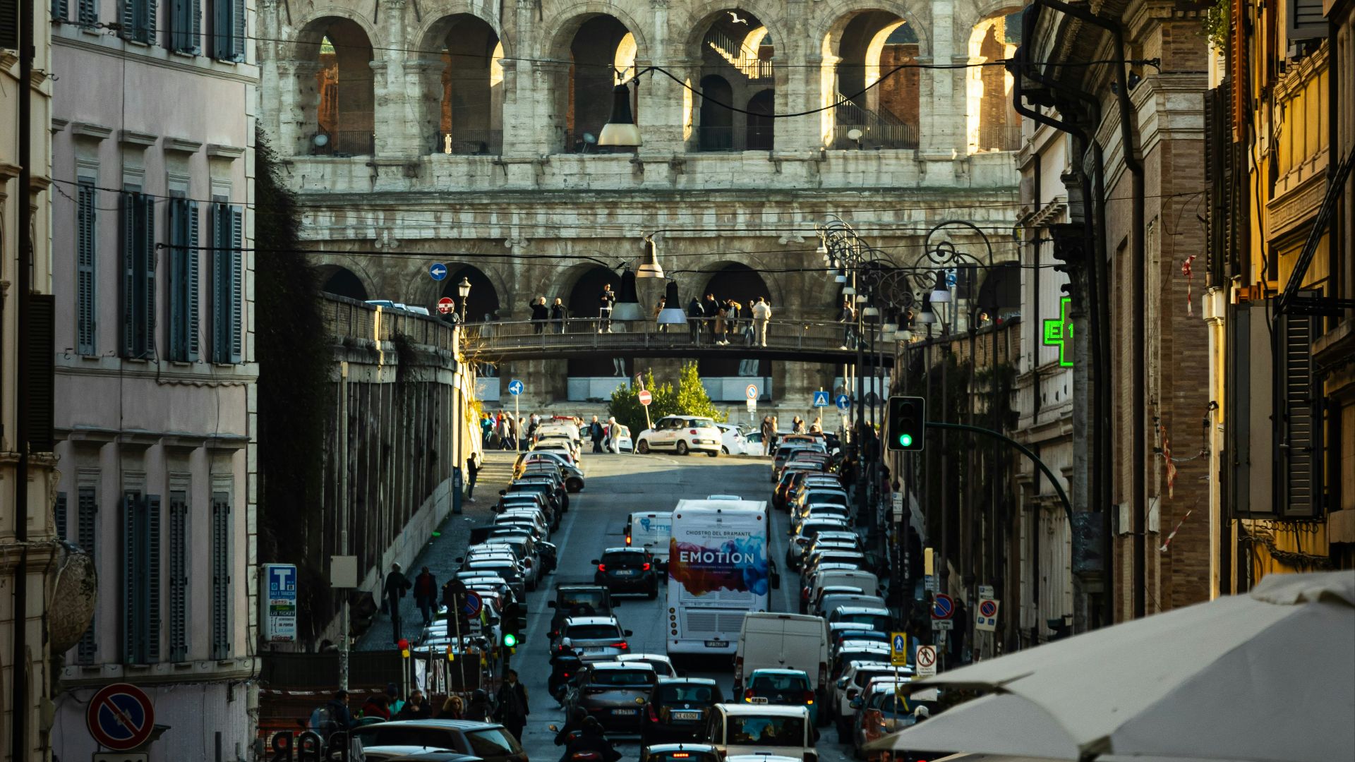 a city street filled with lots of traffic next to tall buildings