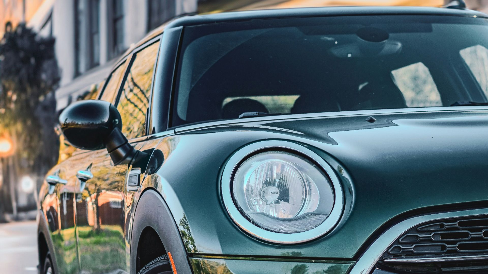 a green mini cooper parked on the side of the road