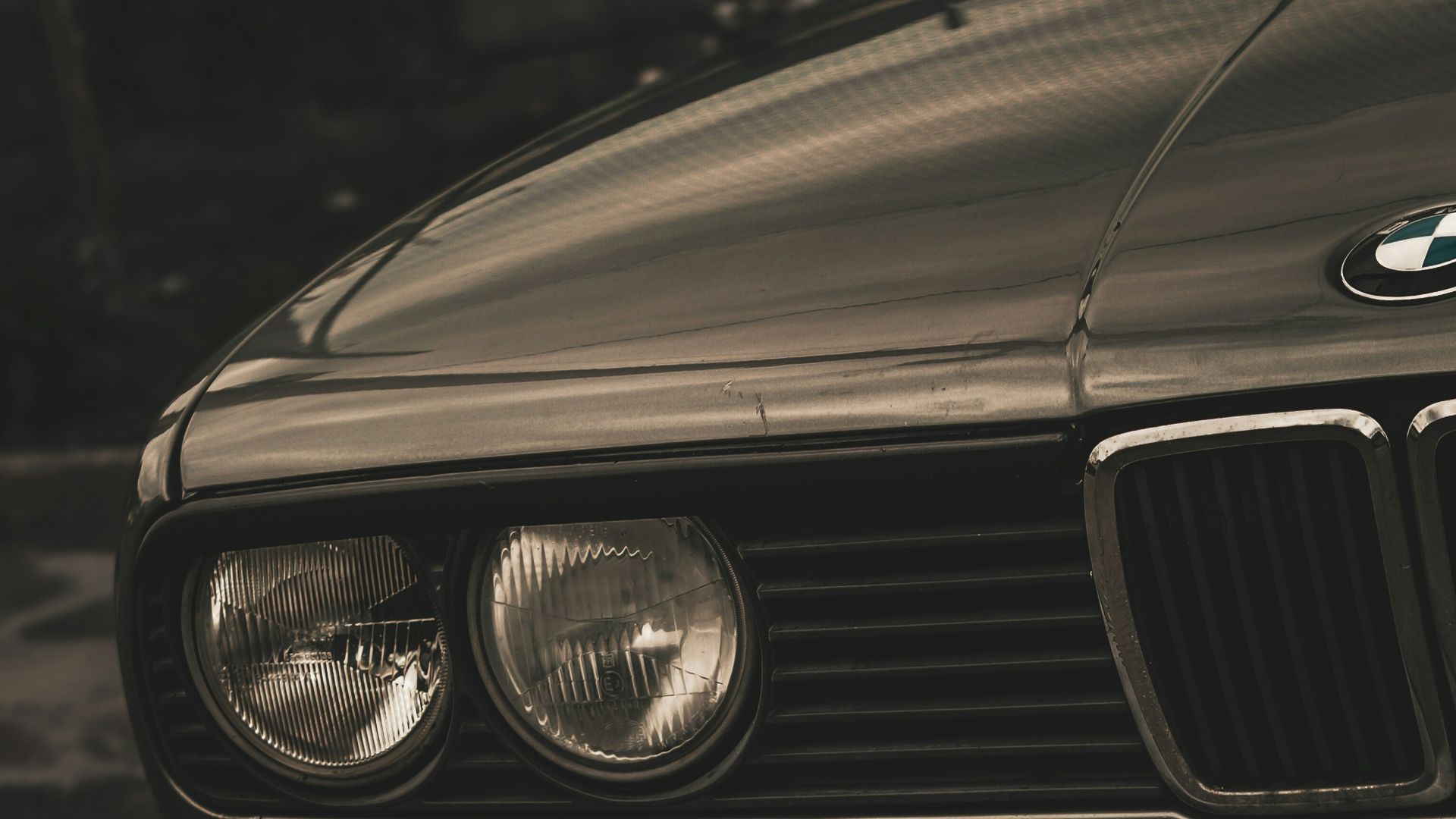 a black bmw is parked on the side of the road