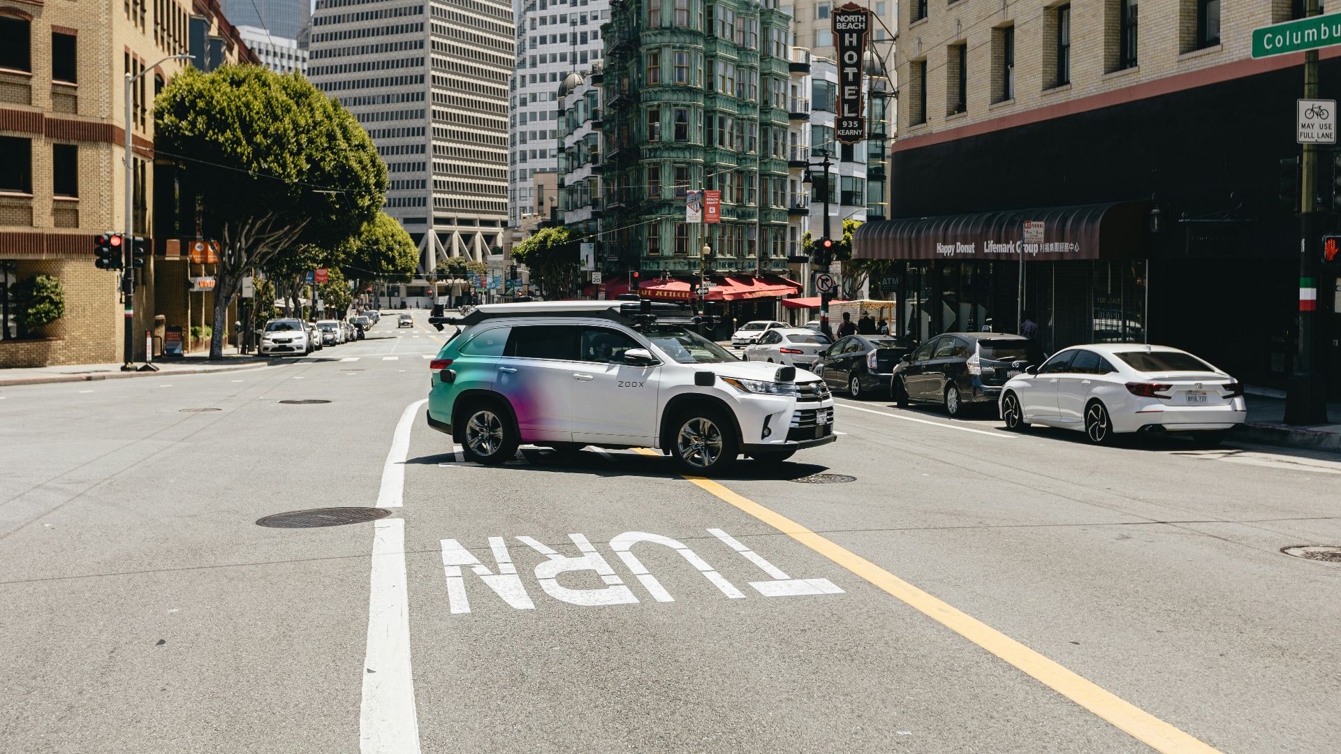 a car driving down a street next to tall buildings