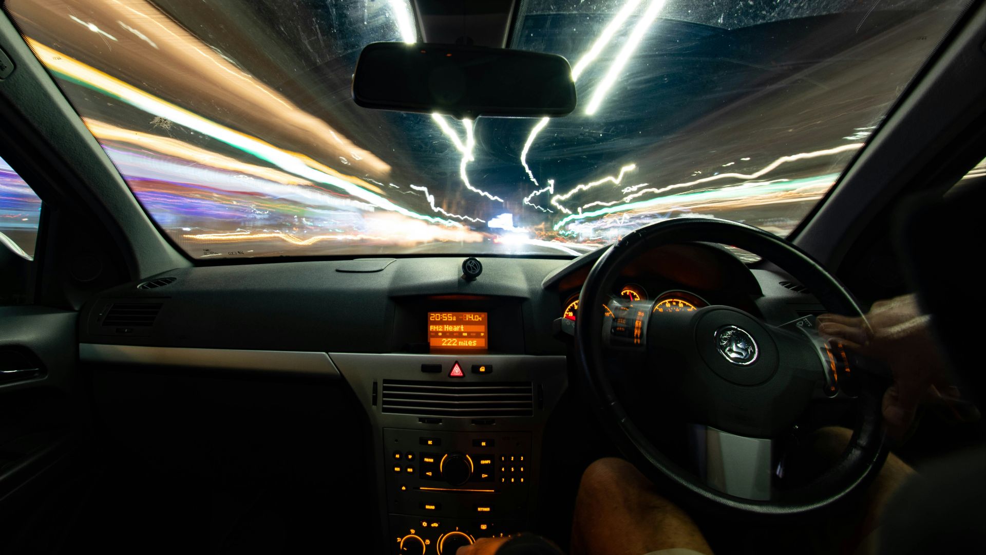 a car driving down a street at night