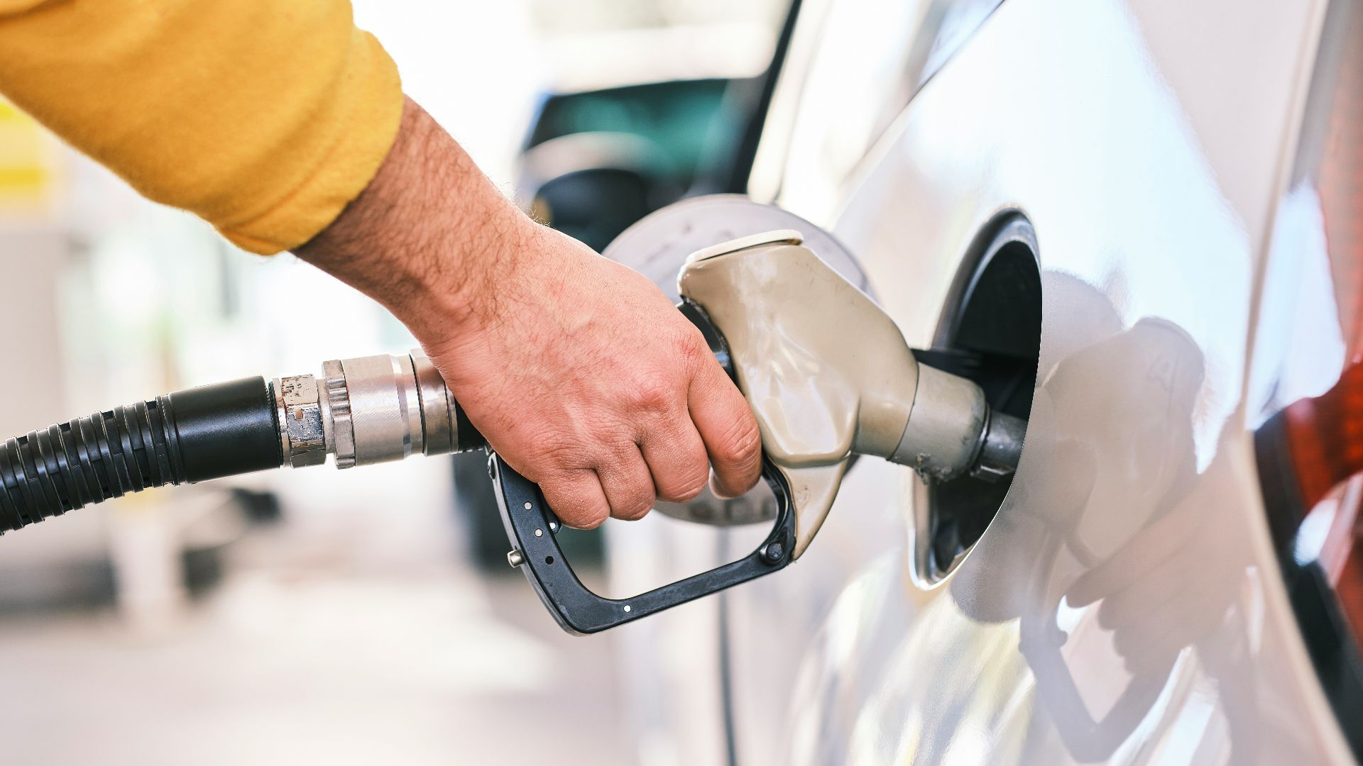 a man pumping gas into his car at a gas station