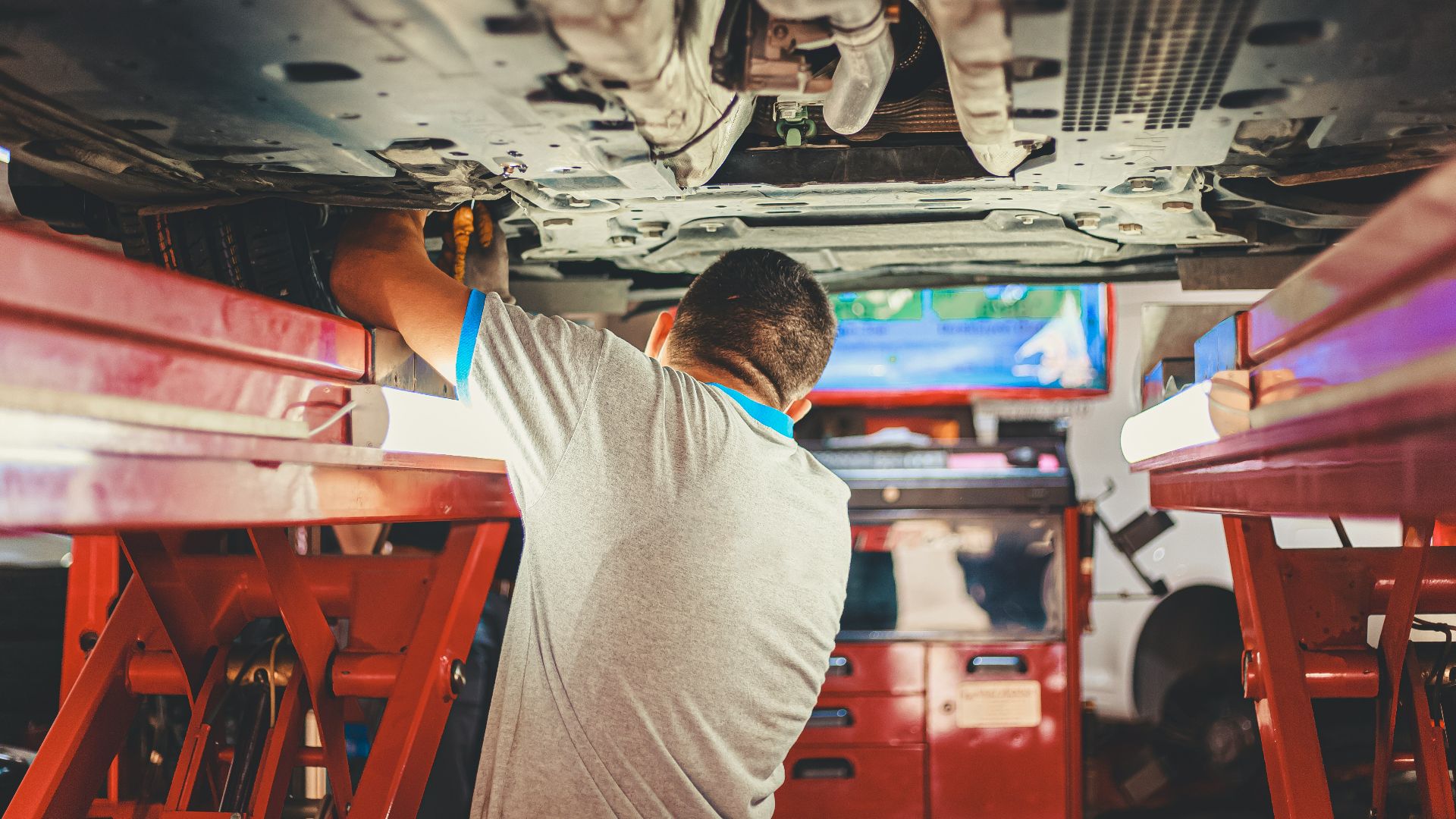 man in gray shirt sitting on red plastic chair